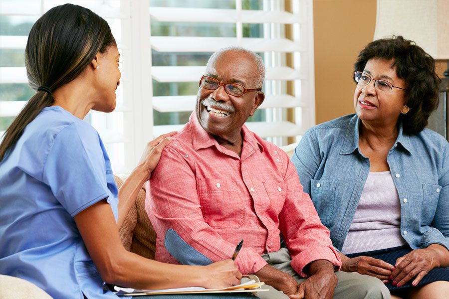 Senior Care Facility Insurance - Home Nurse Meeting with Older Couple in the Living Room