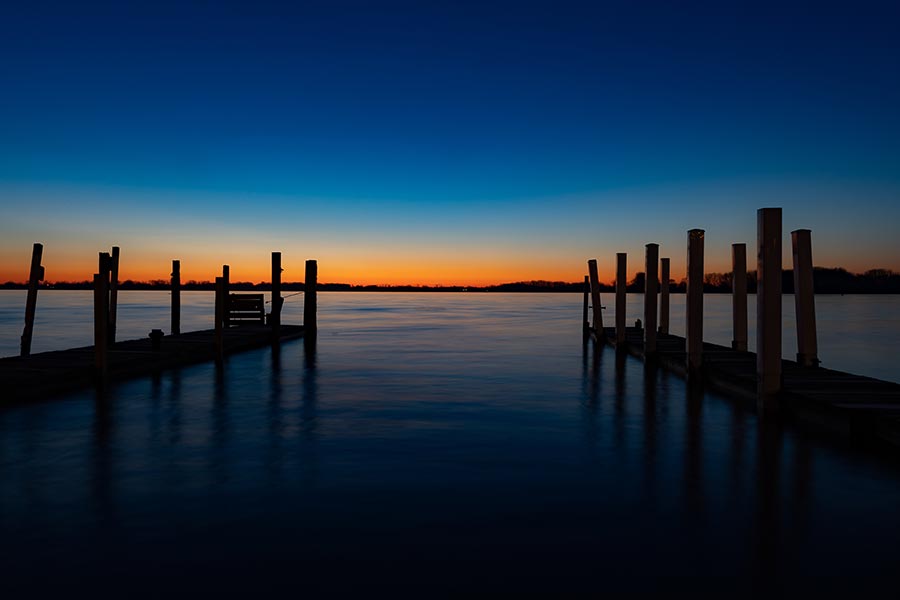 Wyandotte, MI Insurance - Two Wooden Piers at Twilight, the Horizon Glowing Gold and Sky Overhead a Deep Blue